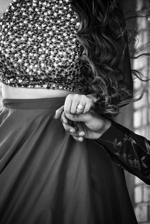 a close up of a women's engagement ring holding her fiance's hand