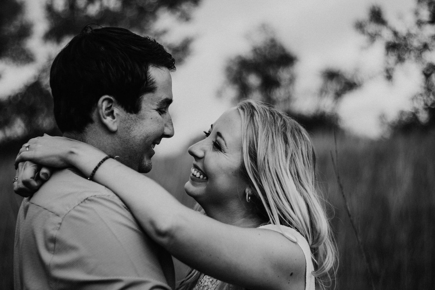A romantic couple shares intimate moments in a series of black and white photos outdoors.