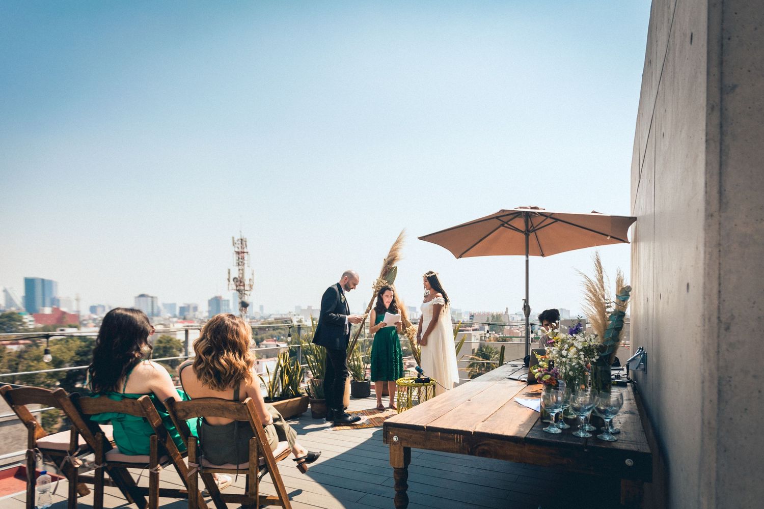 Panoramic view of wedding celebration on modern city rooftop.