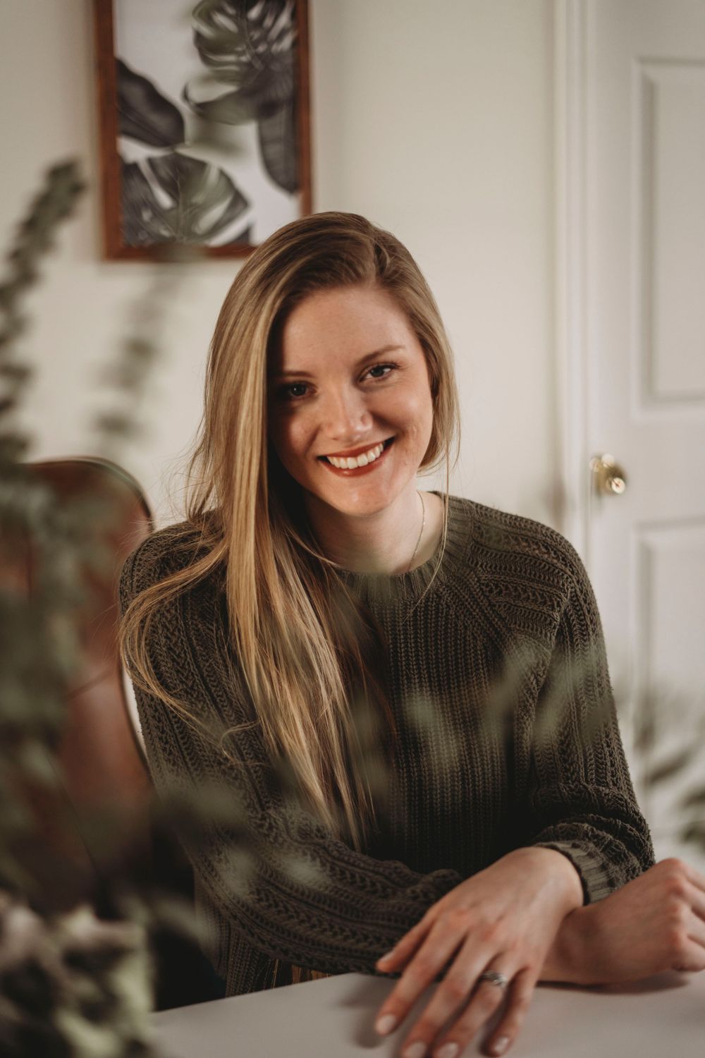 Interior portrait with soft lighting and tropical plant decor.