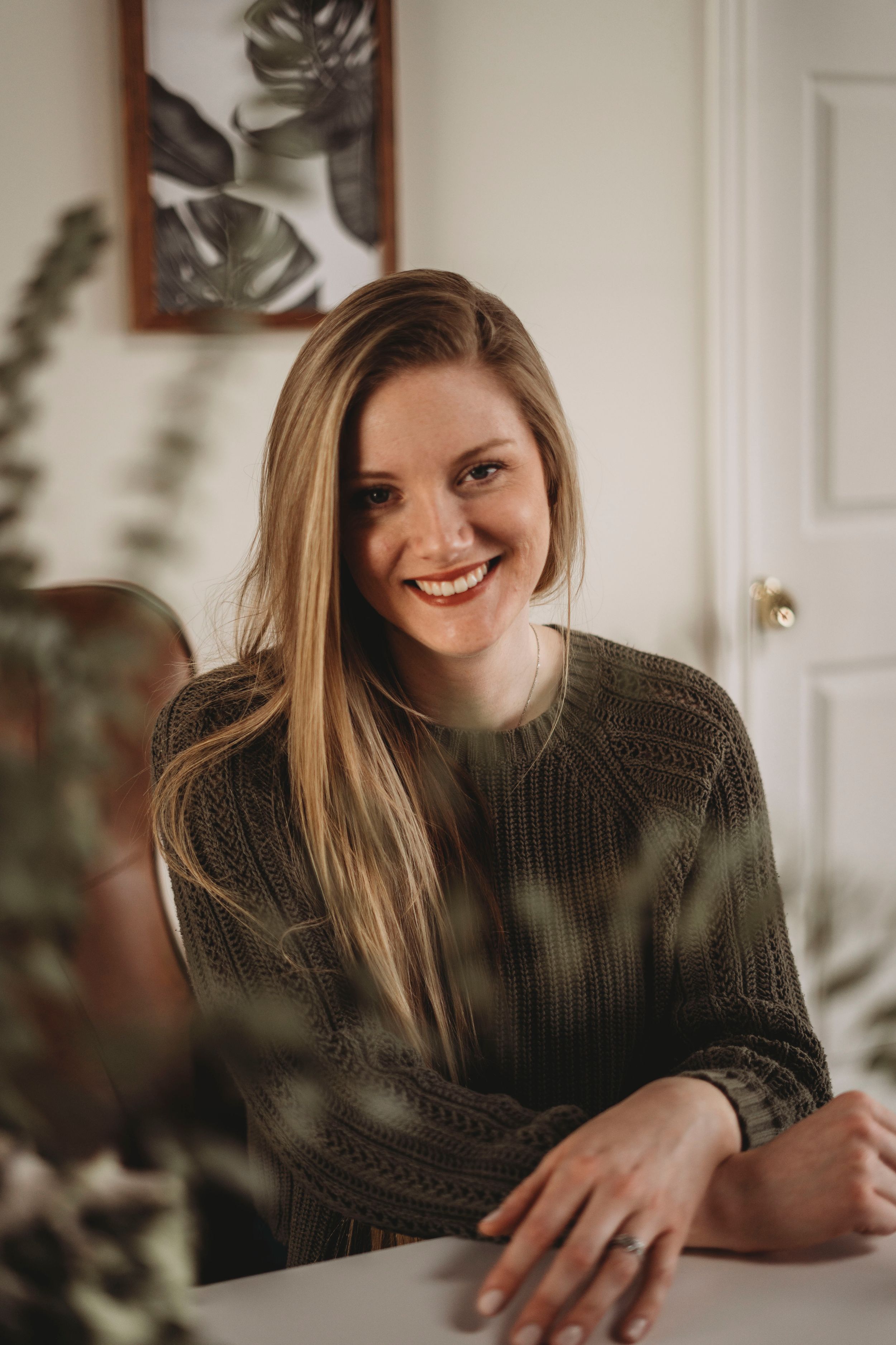 Interior portrait with soft lighting and tropical plant decor.