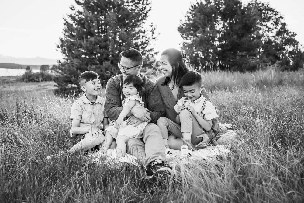Black and white photo of smiling family on a picnic blanket in Seattle