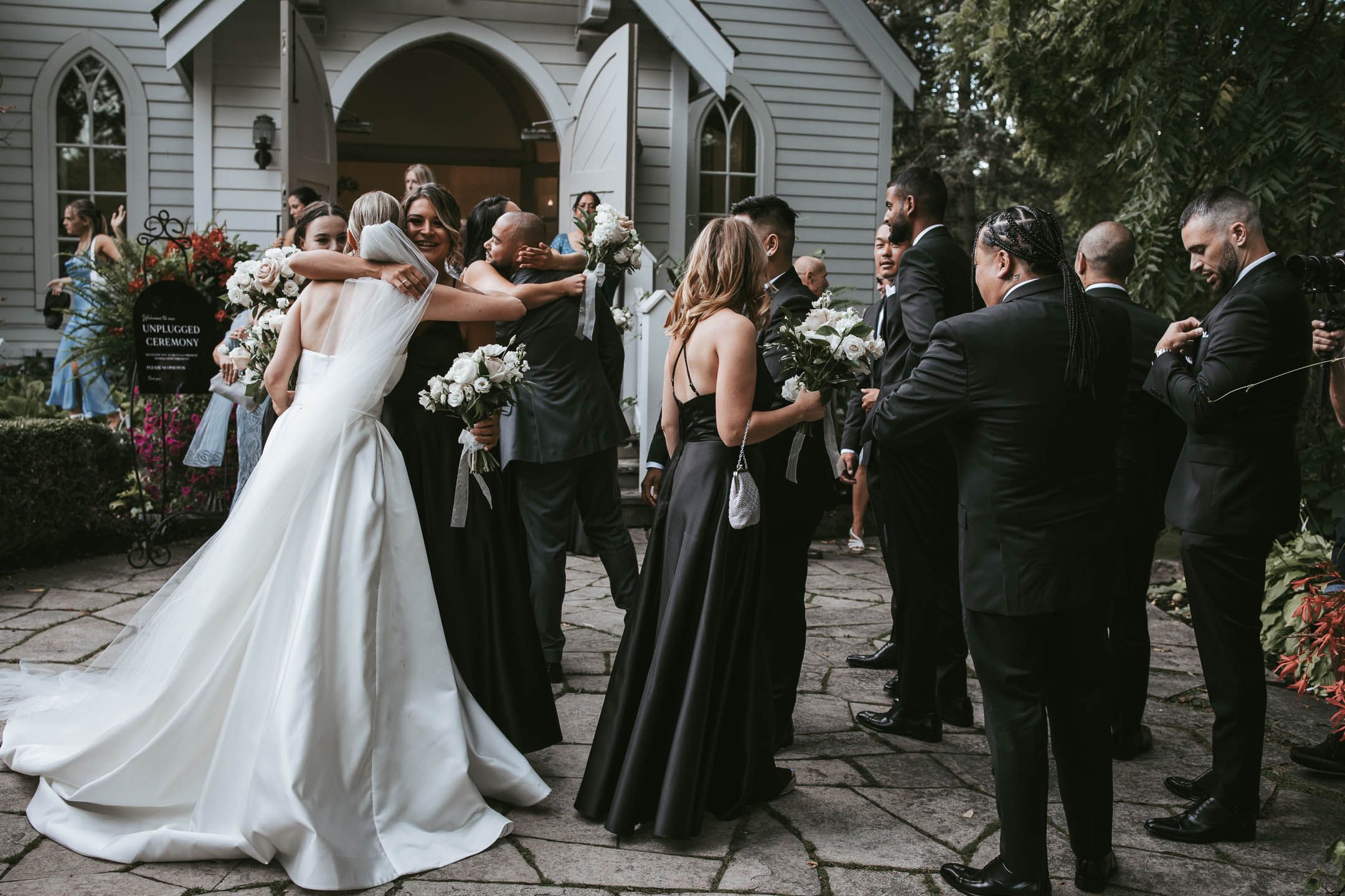 Candid wedding photo of bride hugging her bridesmaid and sharing an emotional moment in a wedding in Toronto Ontario