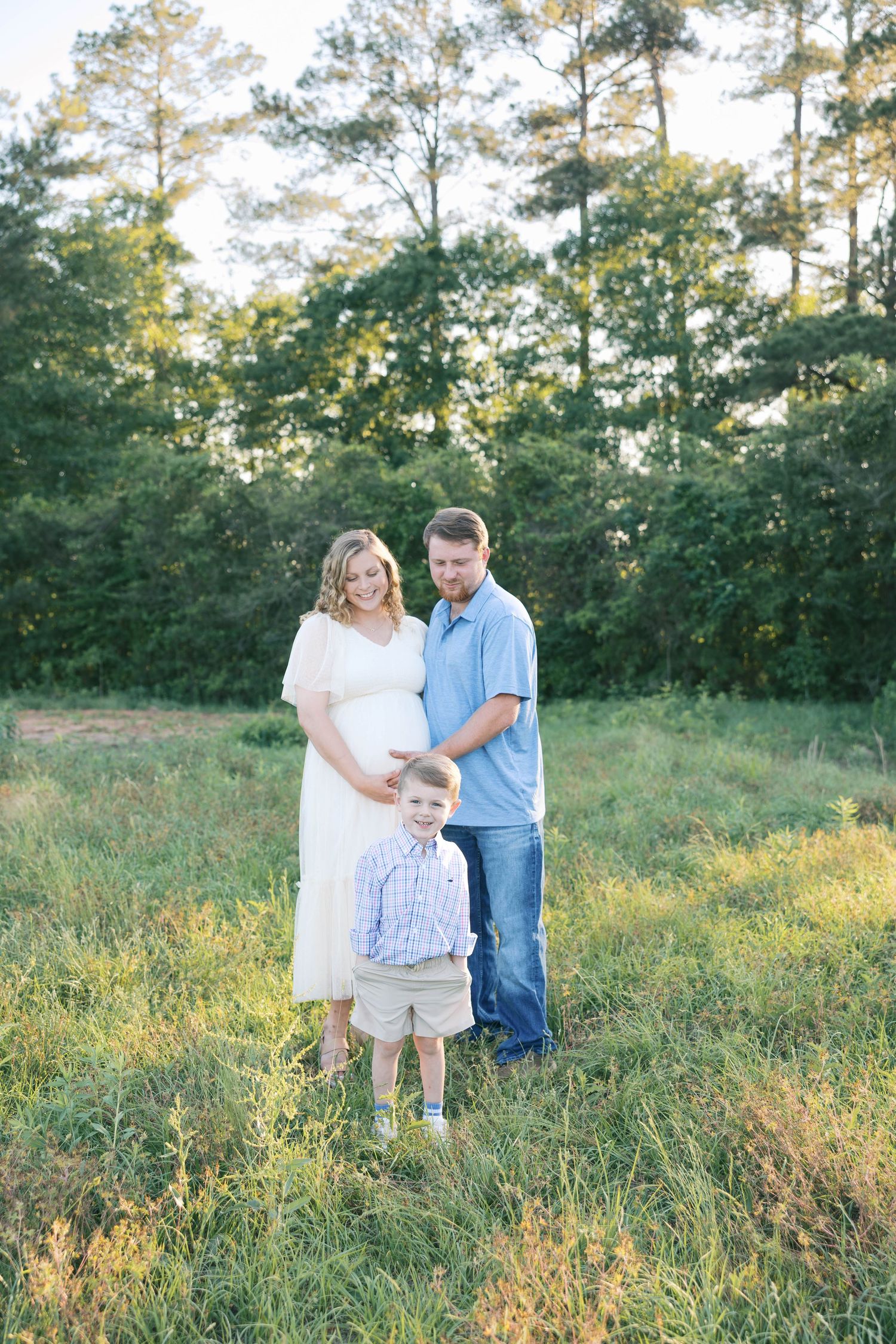Family photoshoot in a rustic field during golden hour sunset.
