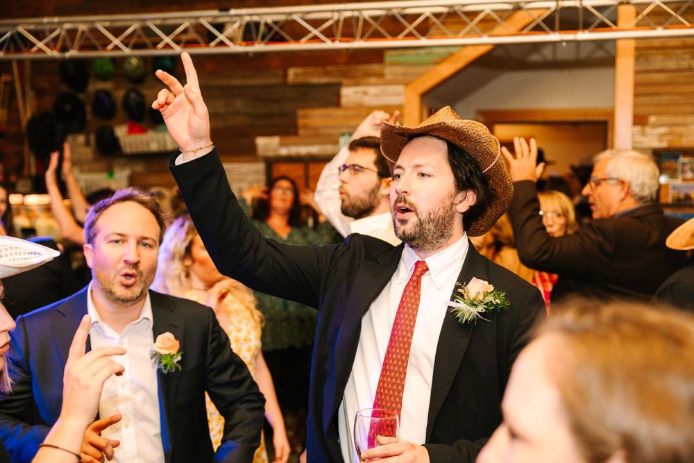 Enthusiastic party-goers celebrating with raised arms at an indoor event.