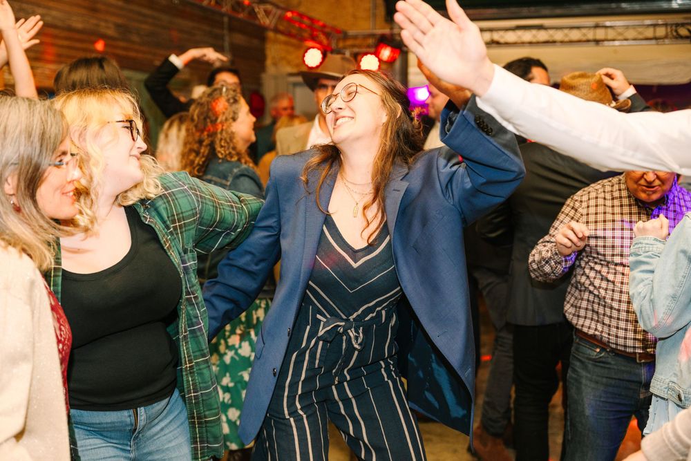 Energetic party scene with dancers enjoying music in casual and western-themed outfits.