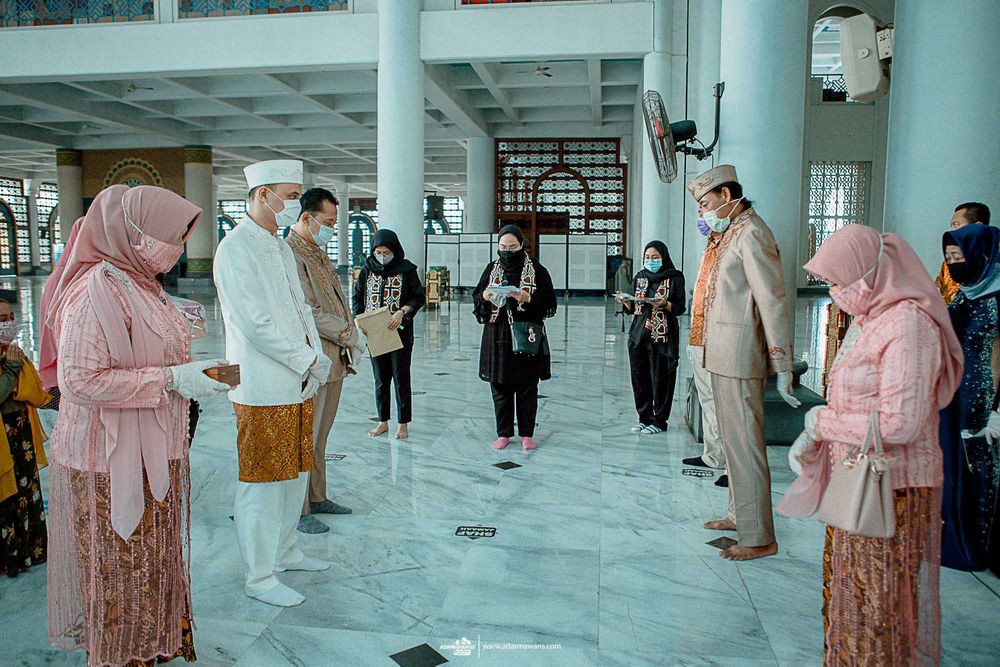 Wedding ceremony participants in traditional Muslim attire gathering in modern mosque interior.