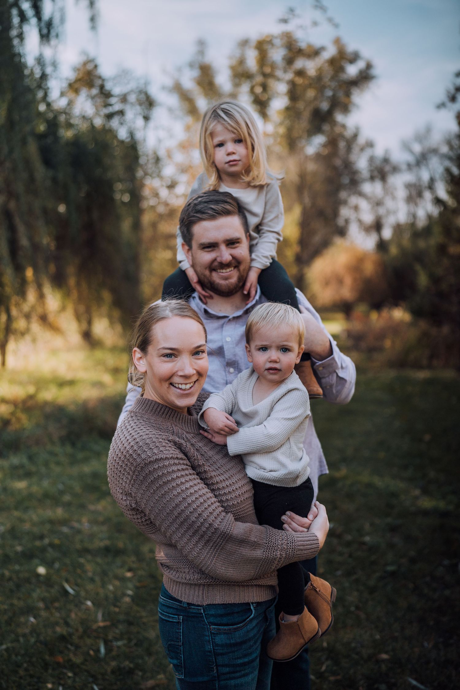 Candid family laughter and embraces photographed in a natural outdoor setting.