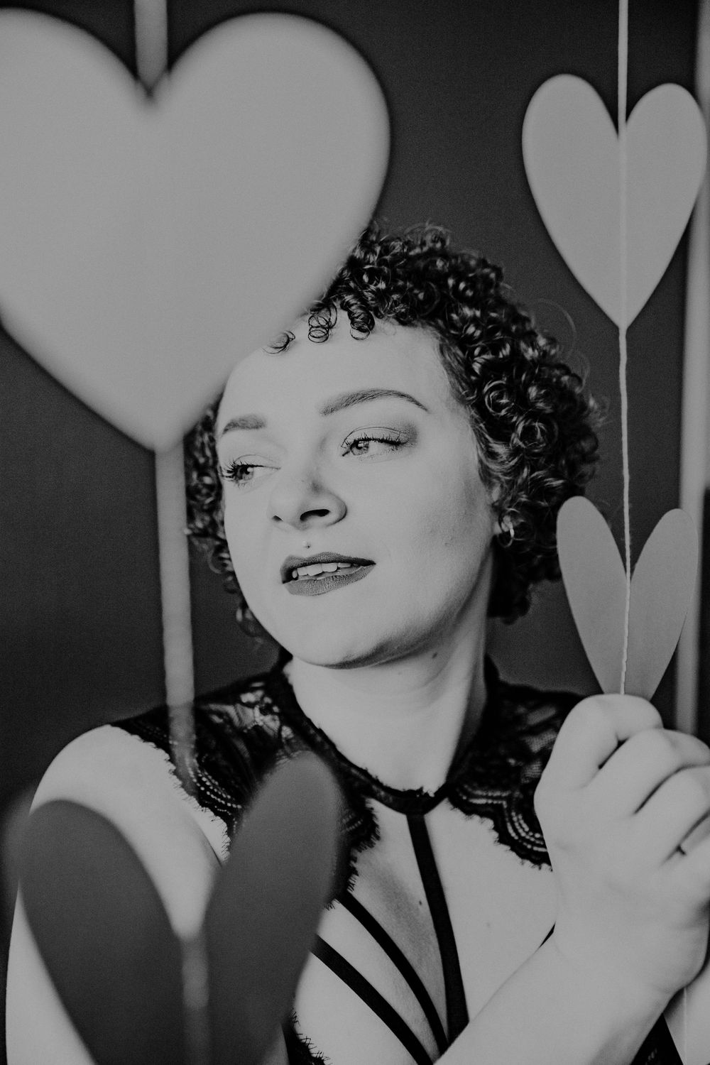 Black and white portrait with decorative heart background and expressive pose.