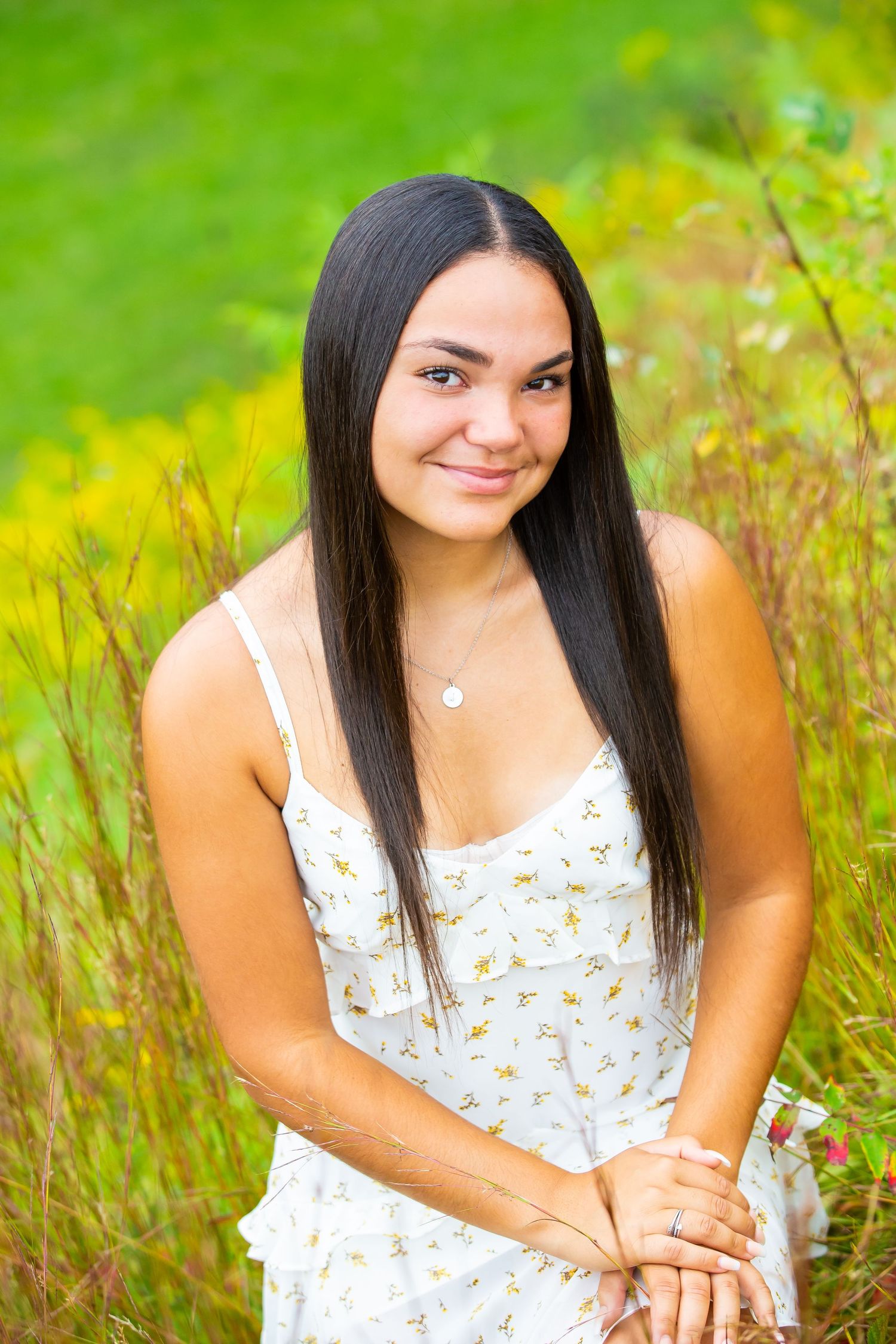 A summer portrait in a field with vibrant yellow flowers and green grass.