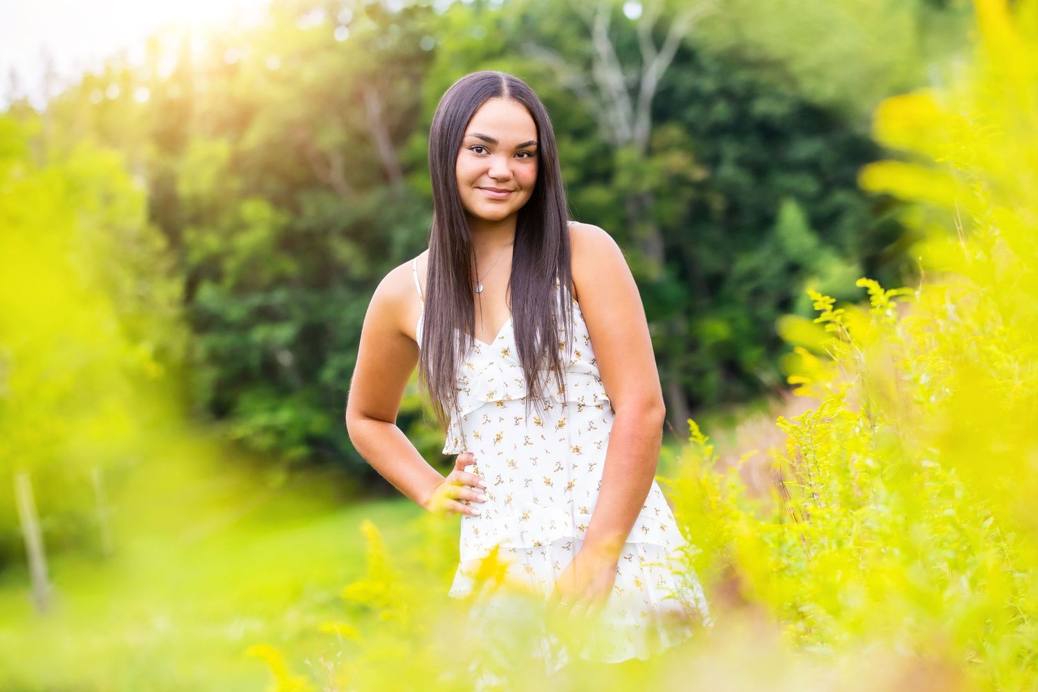 A portrait in a summer garden with yellow flowers and soft sunlight.