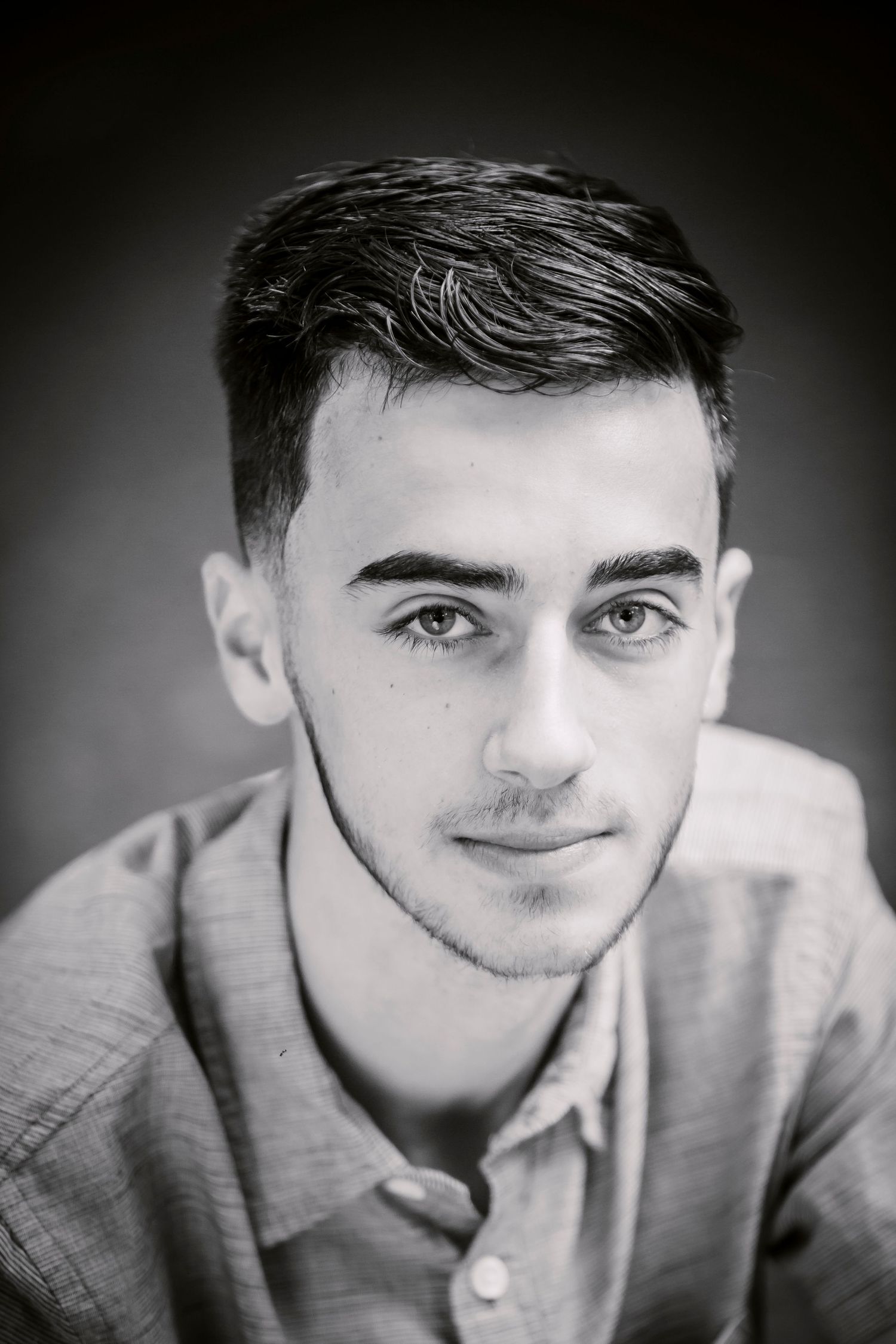 Classic black and white headshot portrait with soft lighting gradient background.
