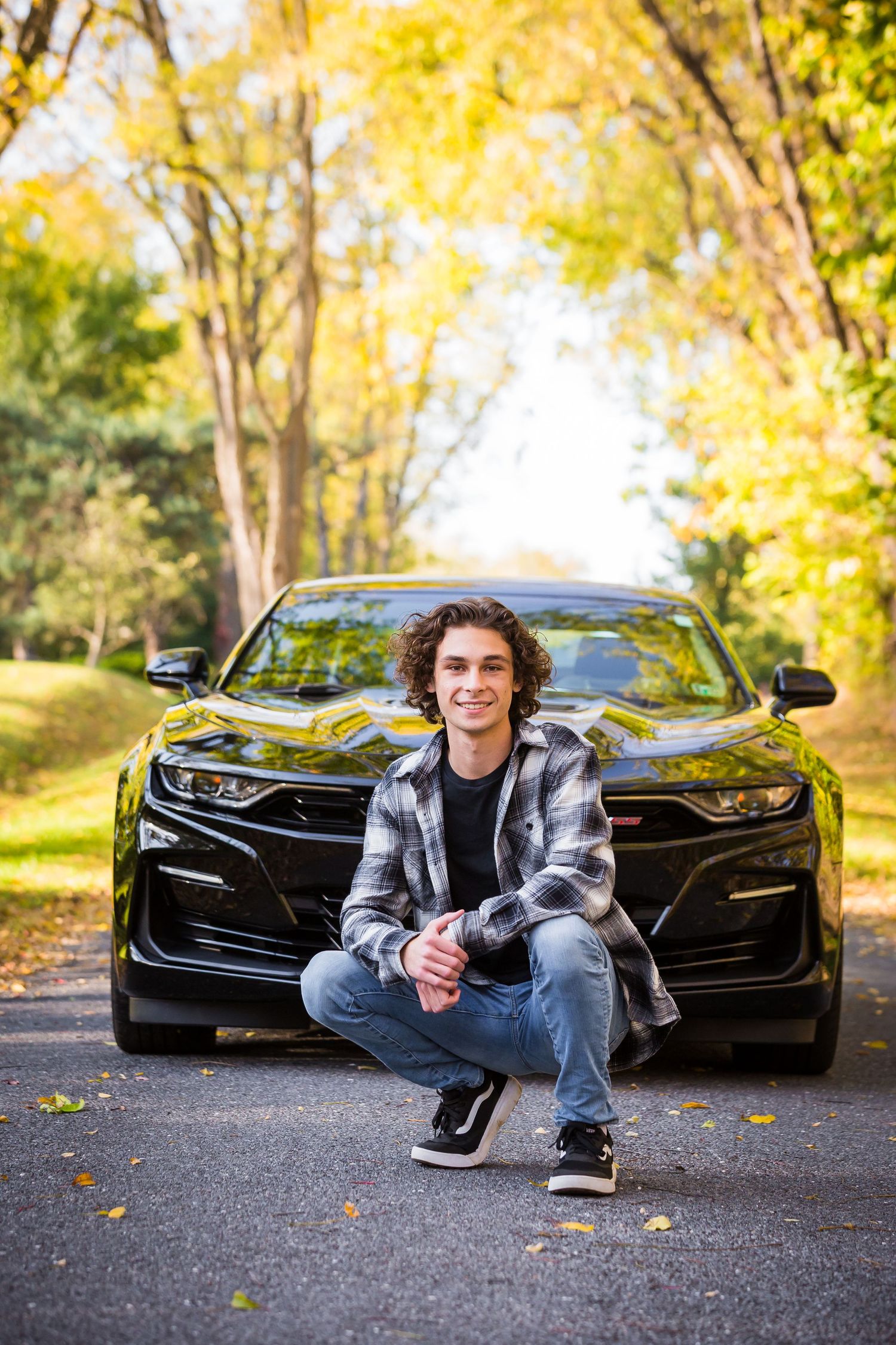 Black Chevrolet Camaro photographed in beautiful autumn setting with fall foliage.