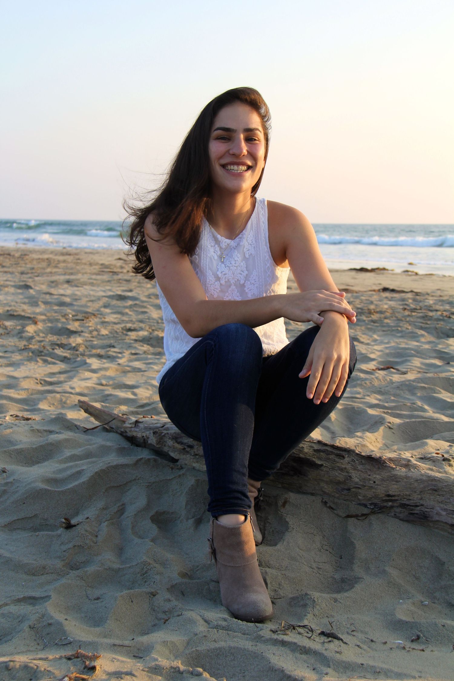 Beach portrait at sunset features casual attire against sandy shoreline.