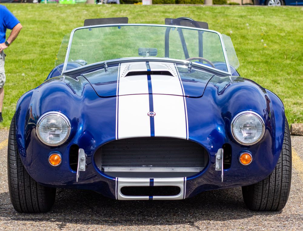 picture of the front of 1960's blue mustang cobra car with white racing stripes