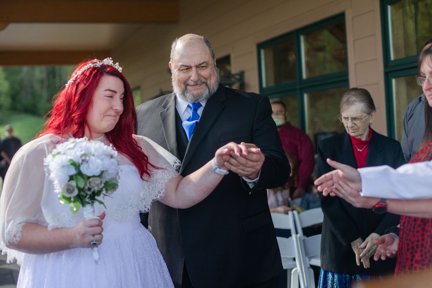 Wedding celebration taking place on a covered deck with scenic mountain backdrop.