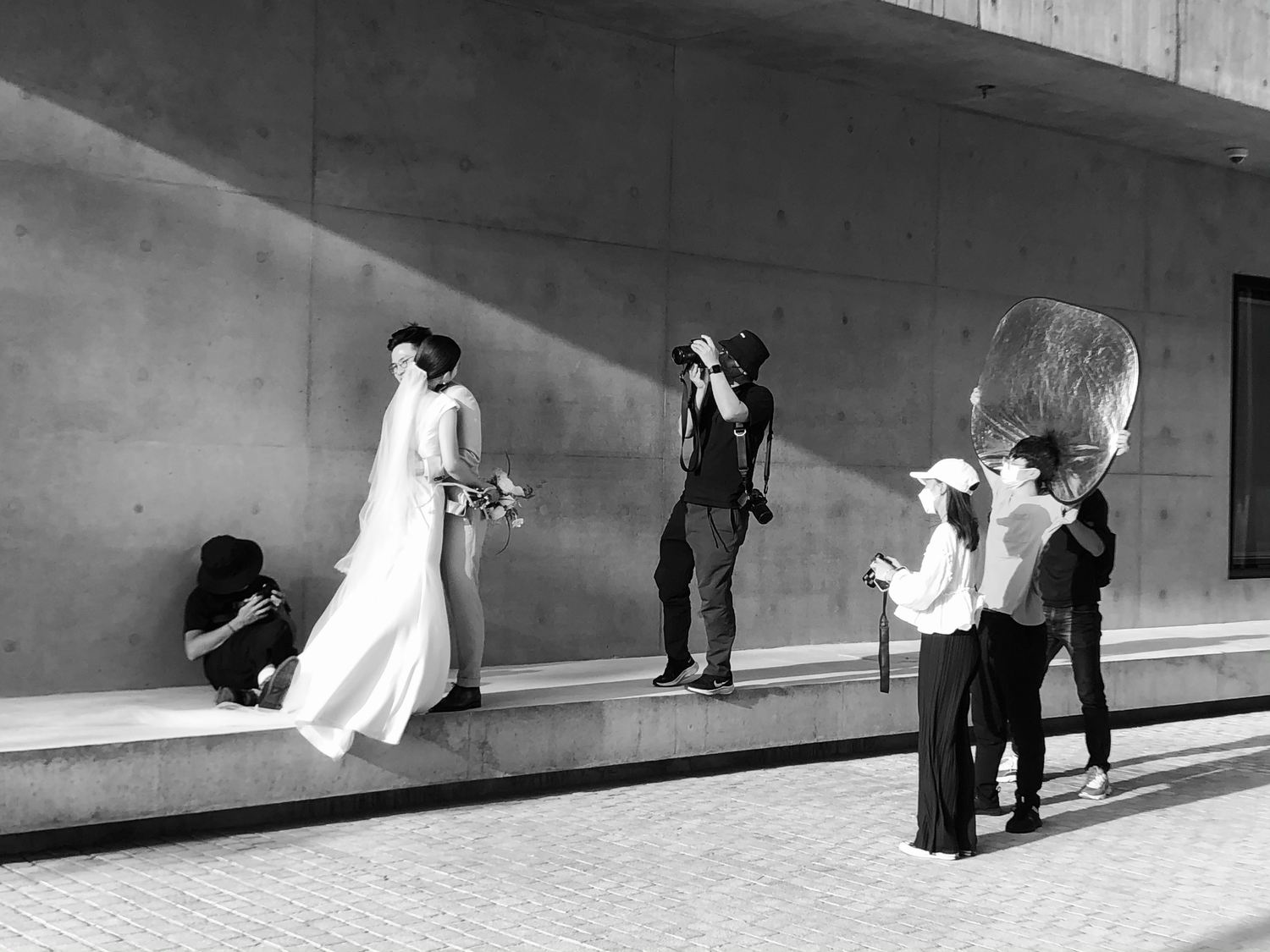 Wedding photography shoot in black and white with photographers and assistants on set.