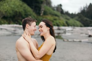 An intimate moment shared between a couple on a misty Pacific Northwest beach.
