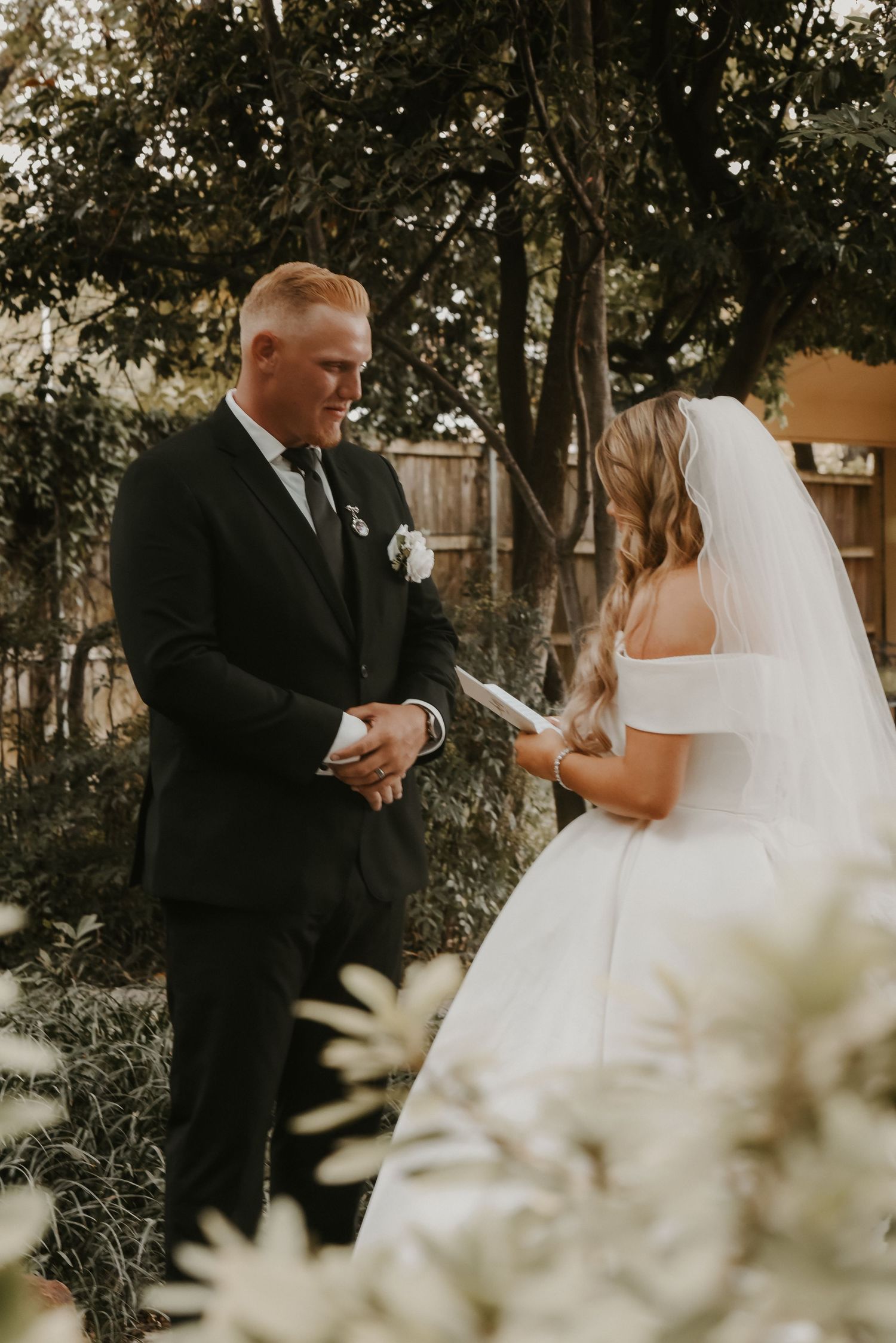 A couple exchanging vows during an outdoor garden wedding ceremony.