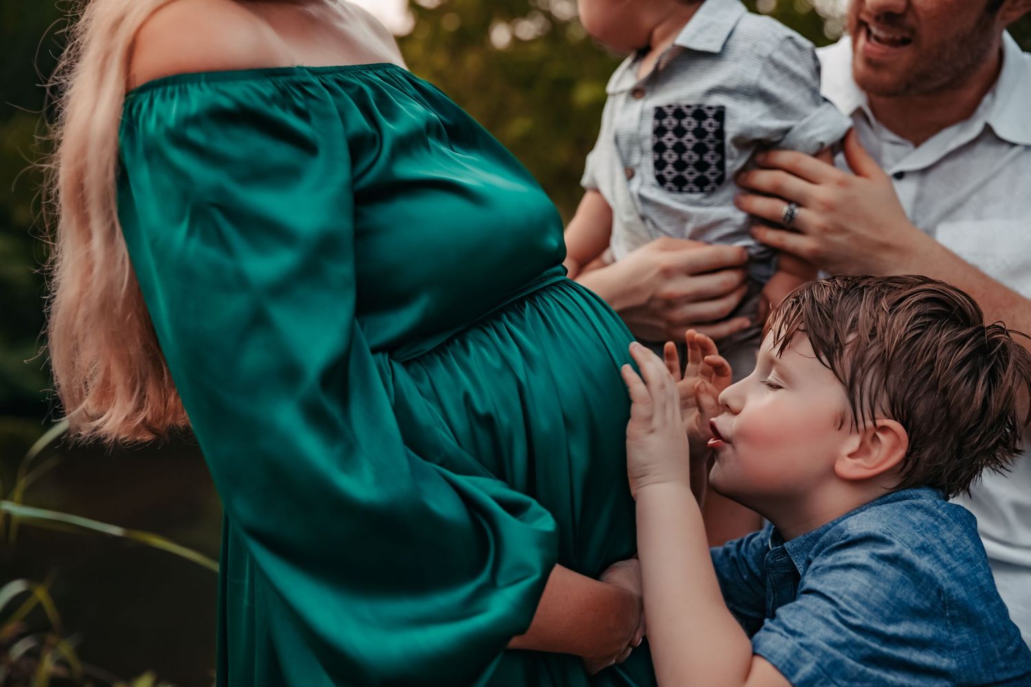 Intimate family moment captured in natural outdoor setting.