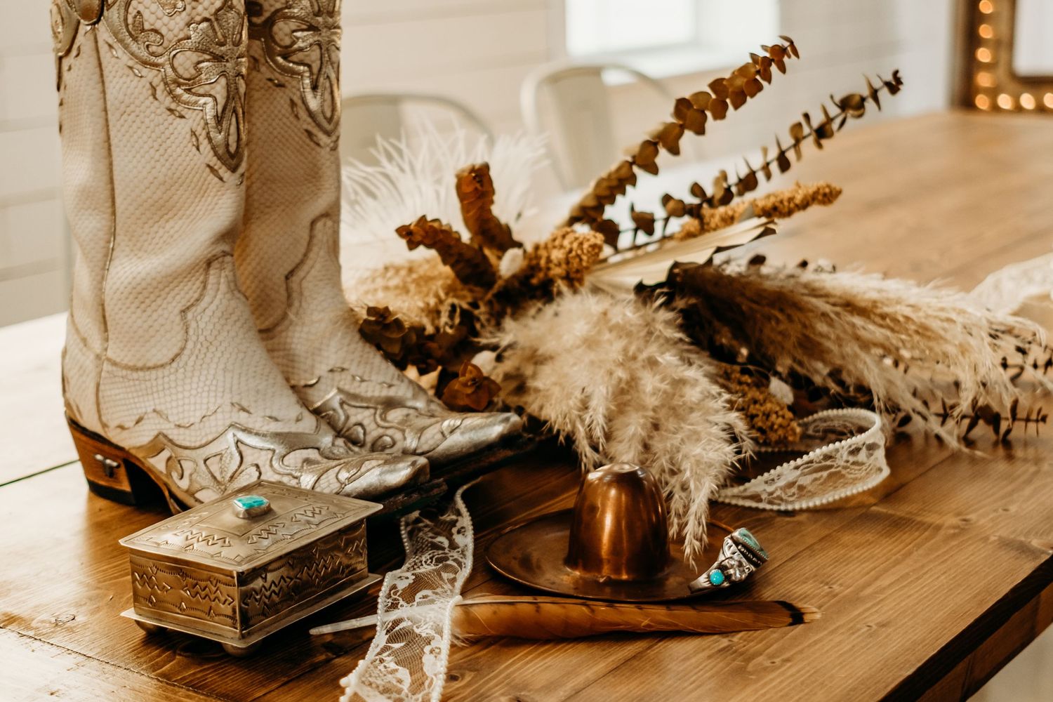 Western-styled boots and rustic decorative items arranged on a wooden table.