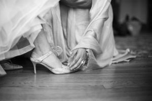 Artistic black and white detail shot of flowing wedding dress against wooden floor. New Haven Lawn Club New Haven CT