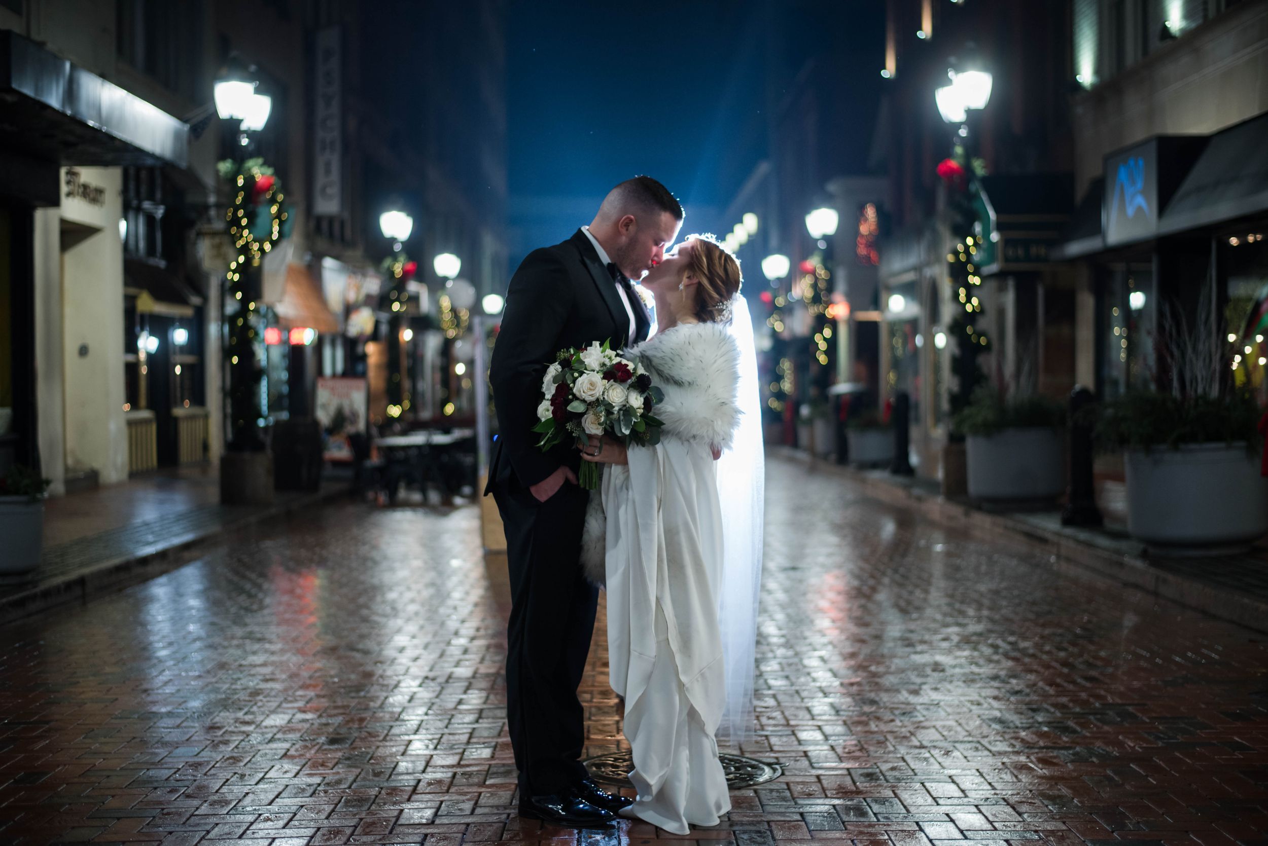Couple dancing in a dimly lit hallway decorated with holiday lights and greenery. The Society Room of Hartford CT