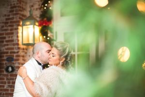 Romantic wedding kiss with soft bokeh lights and brick wall background. New Haven Lawn Club New Haven CT
