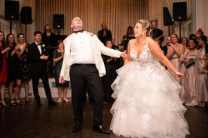 Couple shares first dance surrounded by guests in elegantly lit reception hall. New Haven Lawn Club New Haven CT