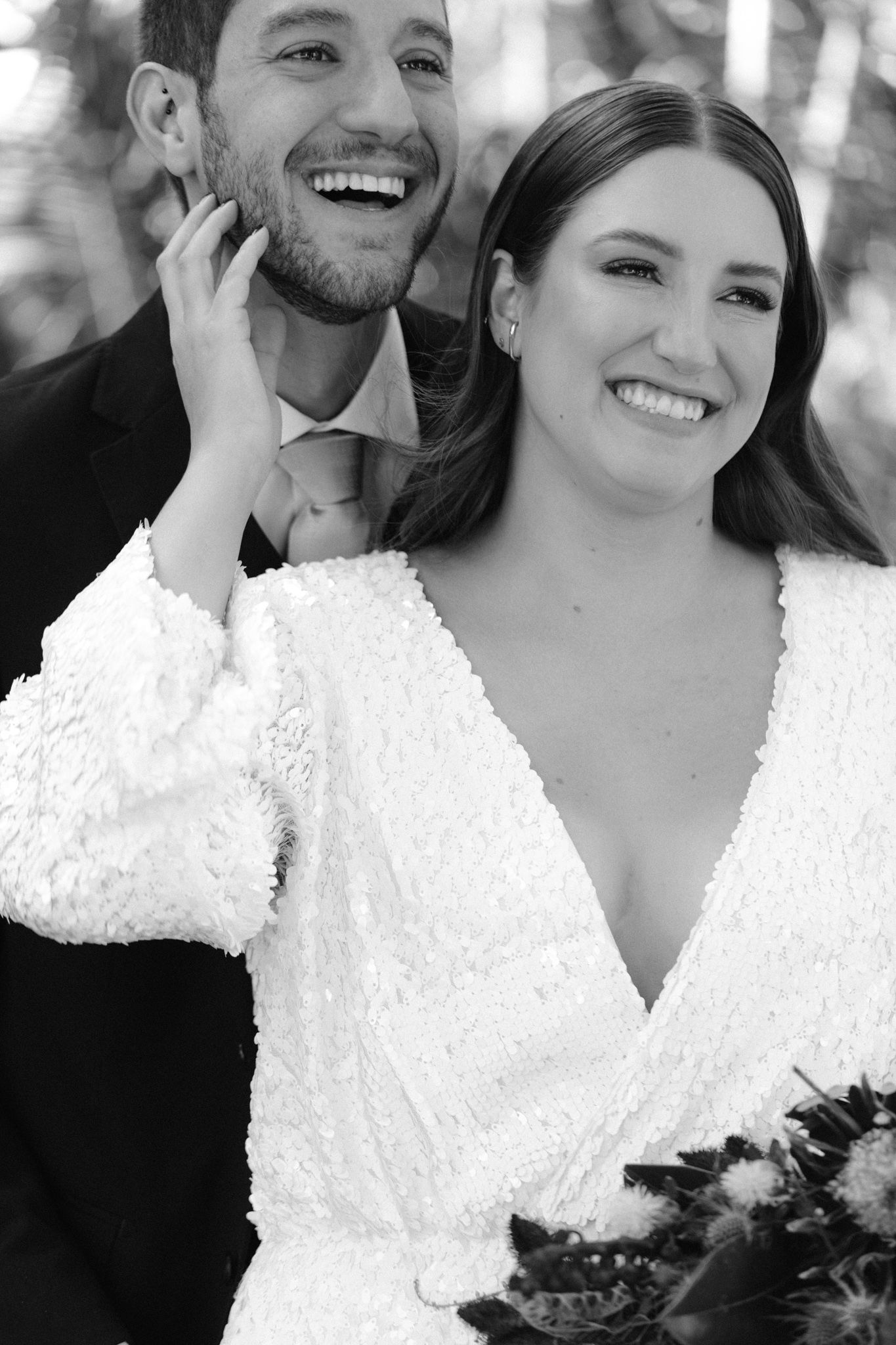 Black and white portrait of newlywed couple sharing a joyful moment.