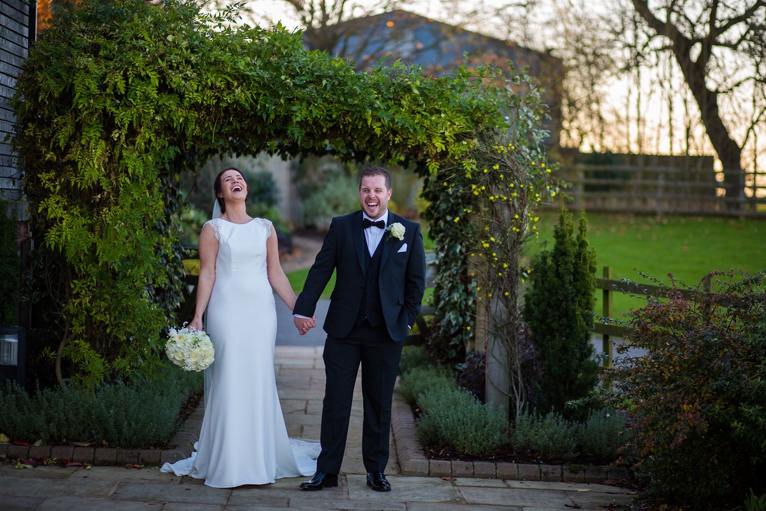 Bride & Groom laughing holing hands at Mythe Barn Wedding Venue