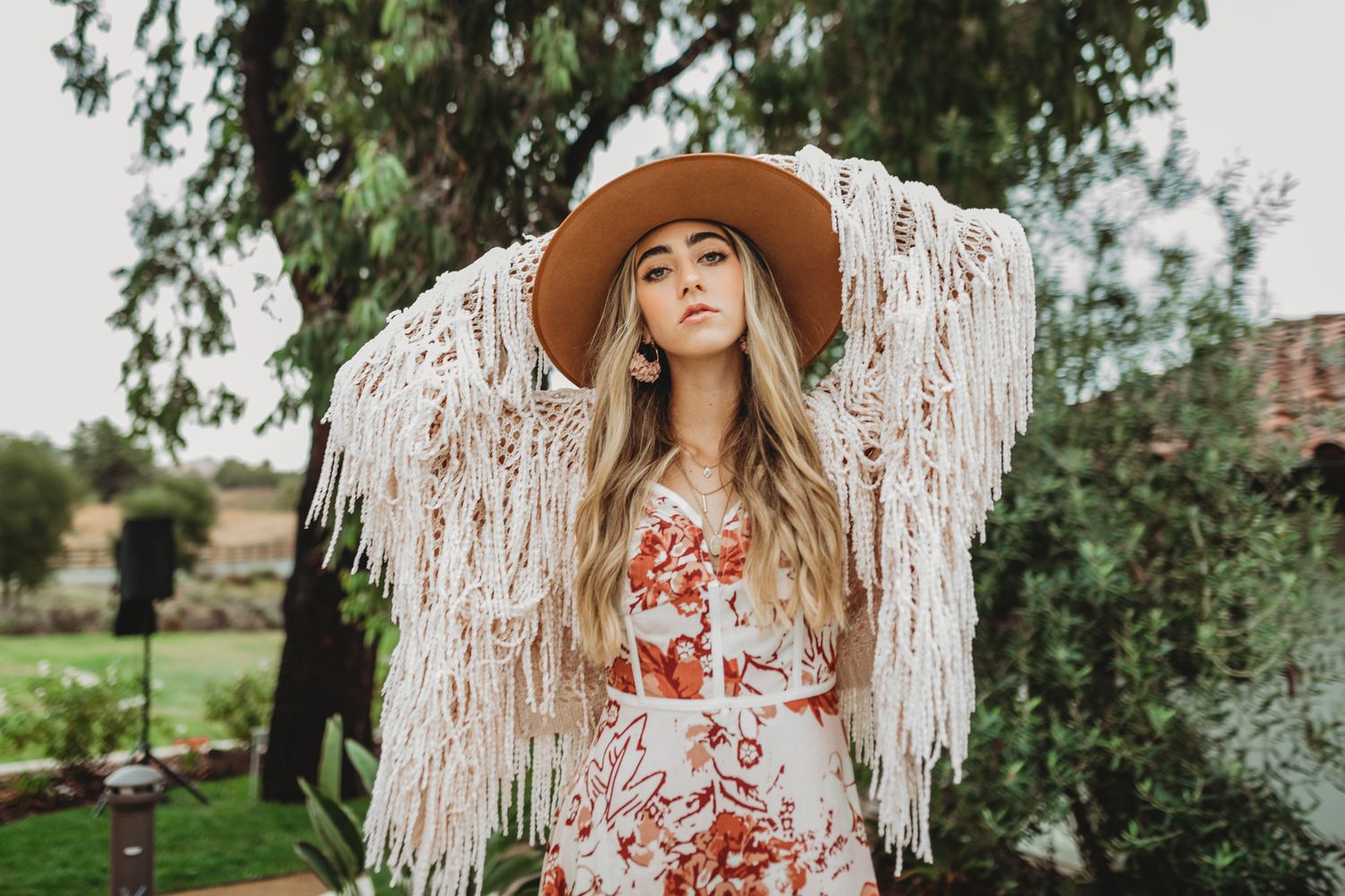 Bohemian style outdoor photography with macrame backdrop and natural scenery.