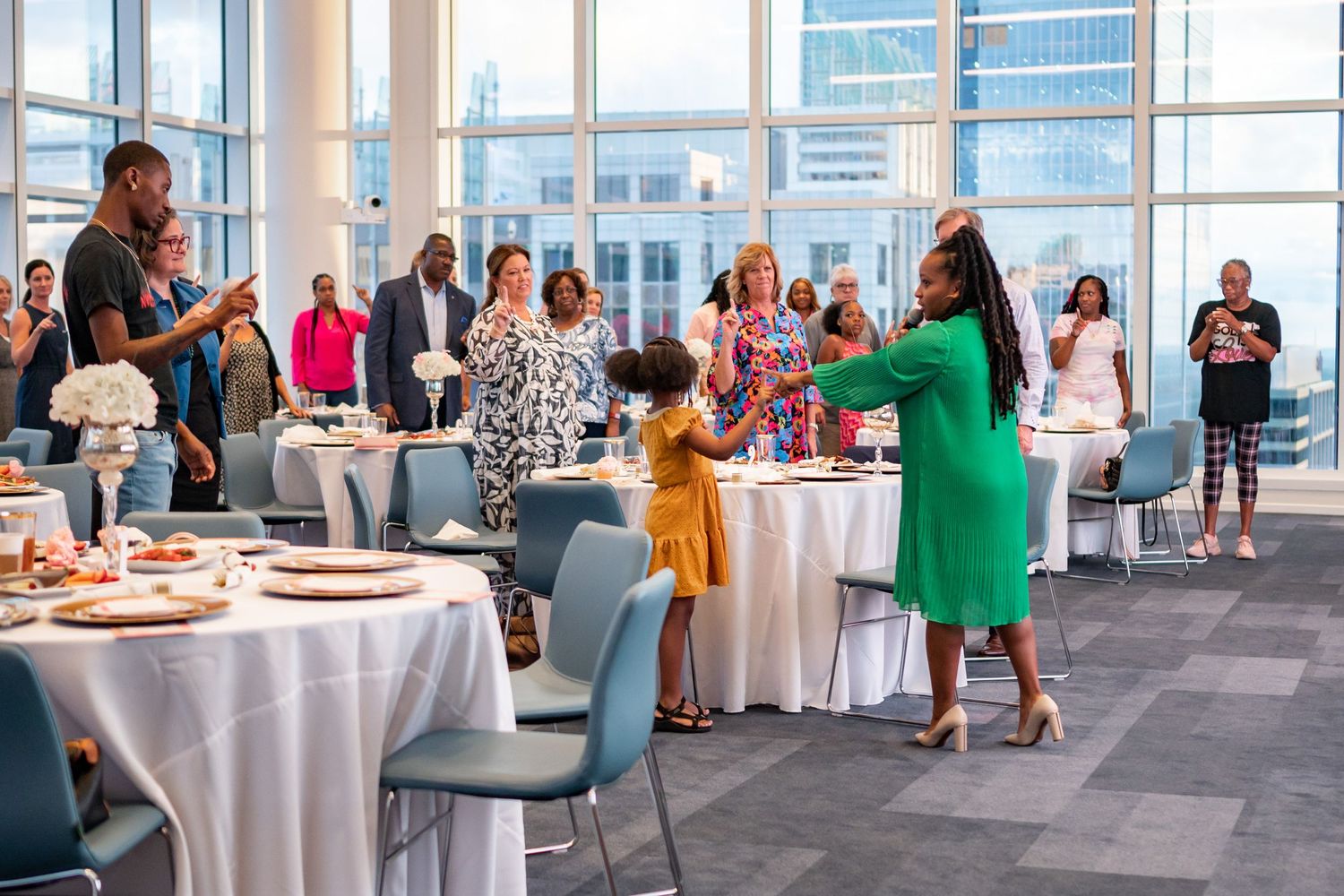 Vibrant social gathering in modern event space with cityscape views through large windows.