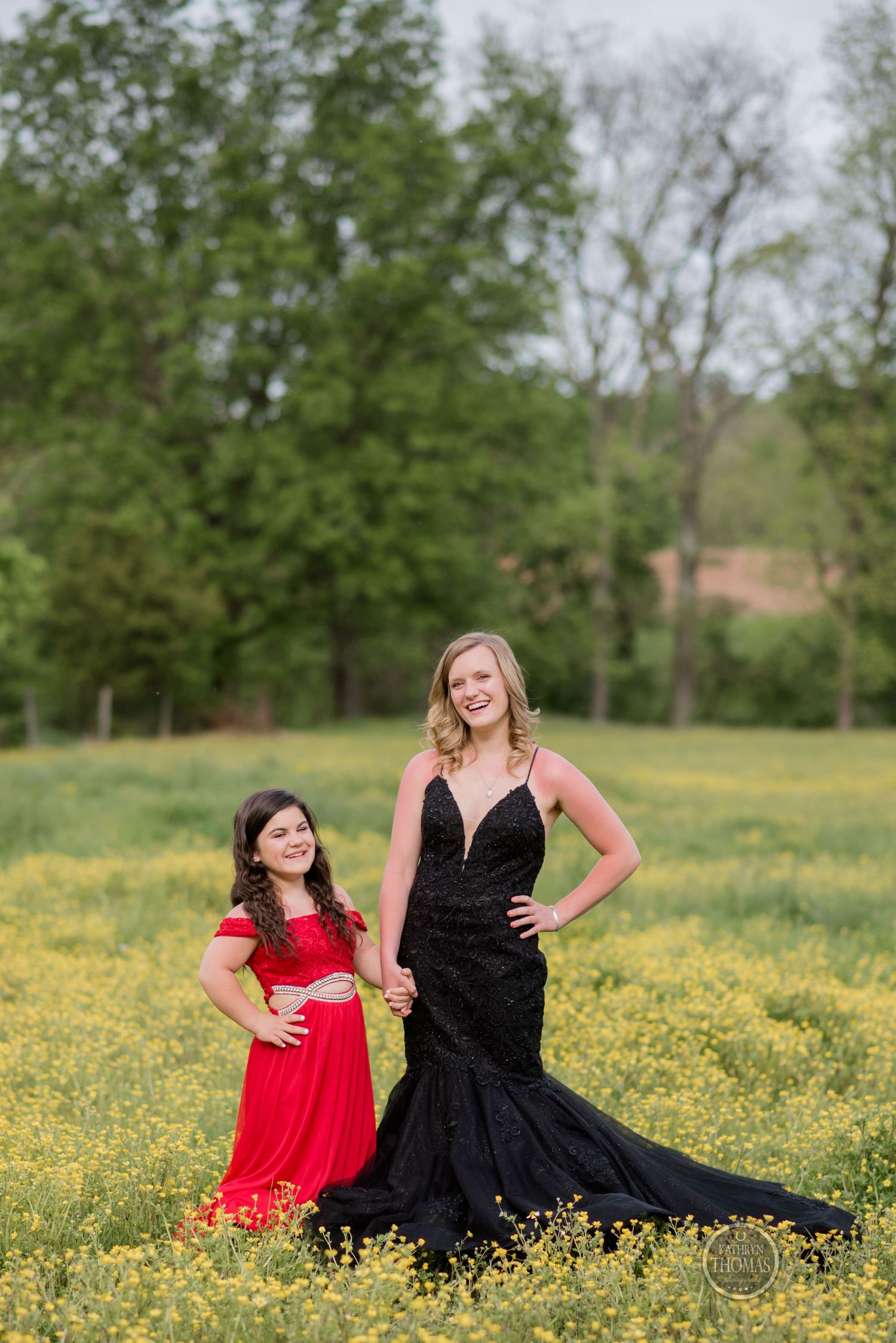 A formal portrait shows two people in elegant dresses standing together in a spring meadow.
