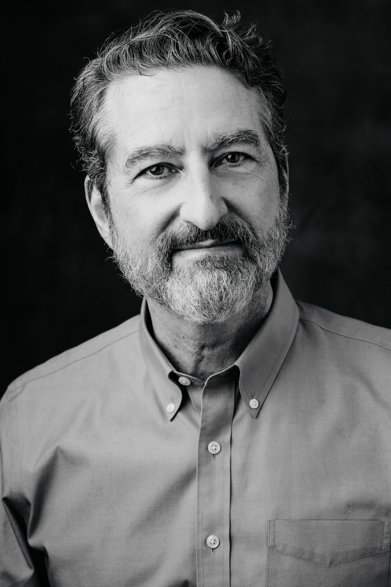 Black and white portrait of person in button-up shirt with natural expression.
