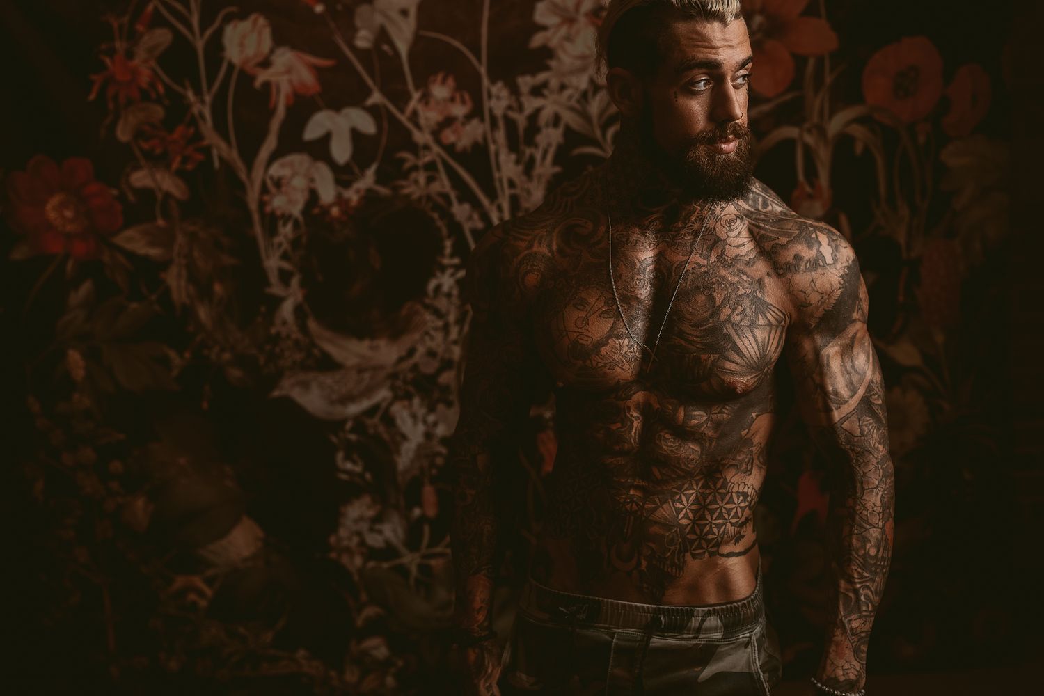 Artistic tattoo photography session showcasing intricate body art in dramatic lighting.