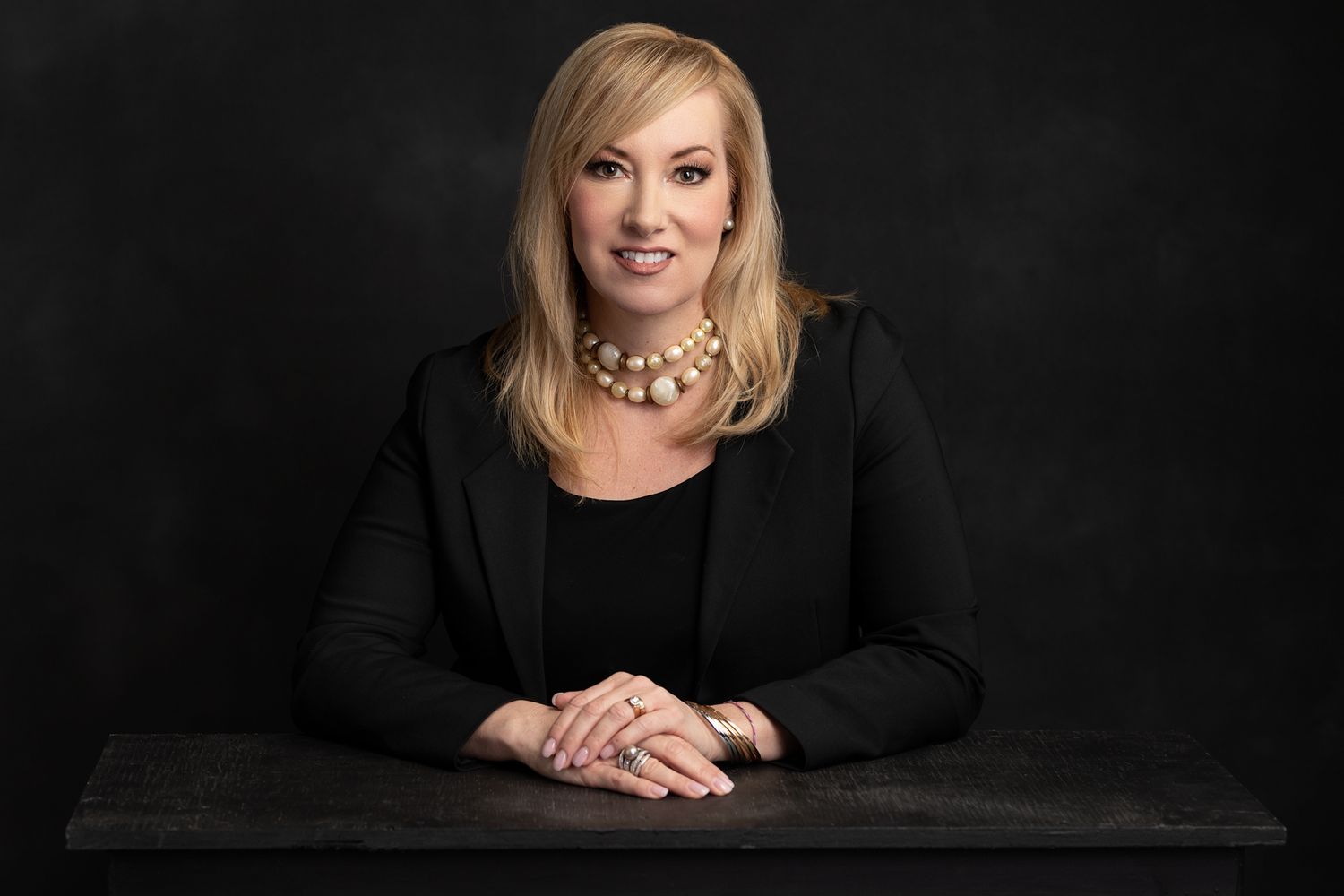 Professional headshots series against dark background with dramatic lighting.