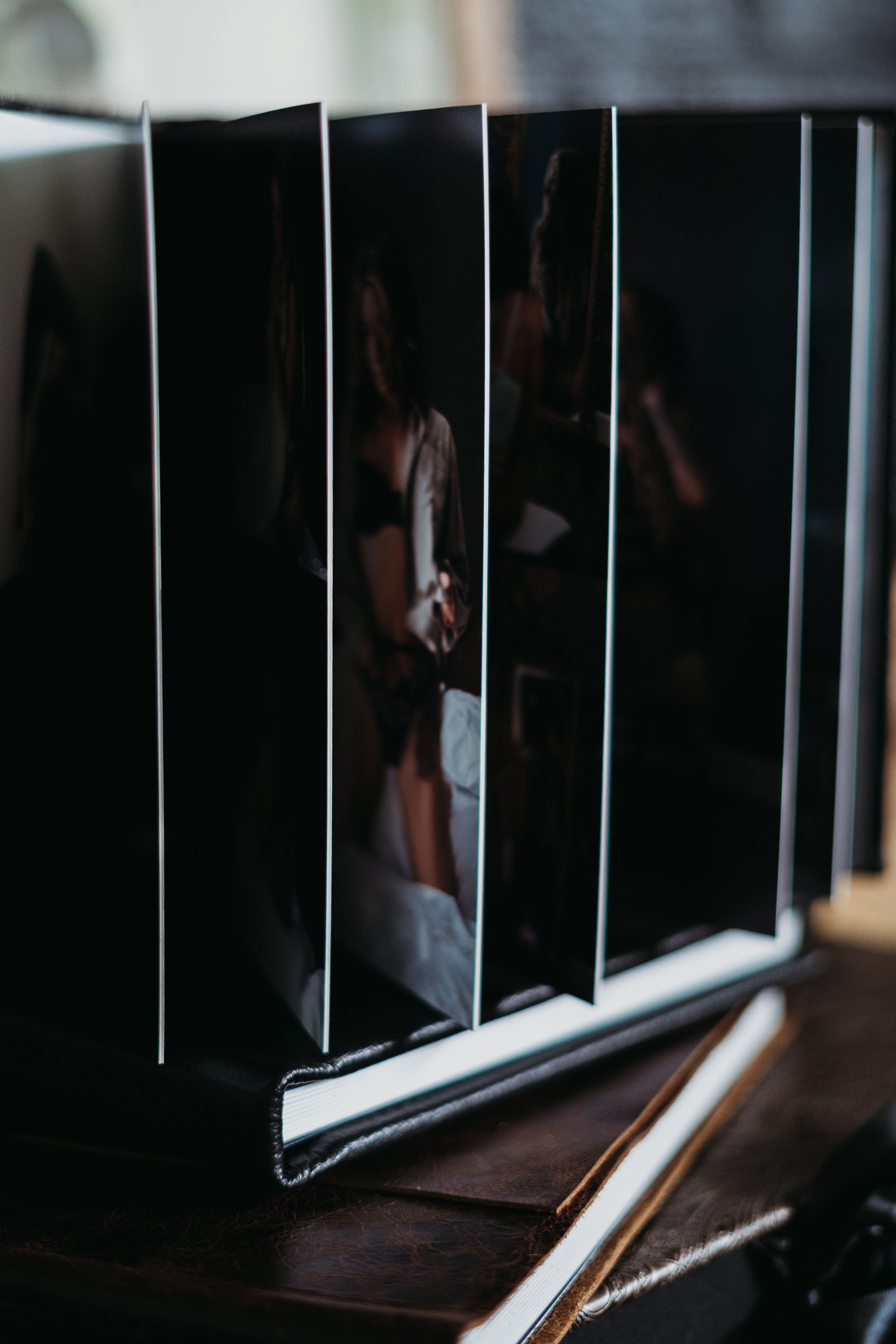 Open photo album showing artistic portrait series with dramatic lighting.