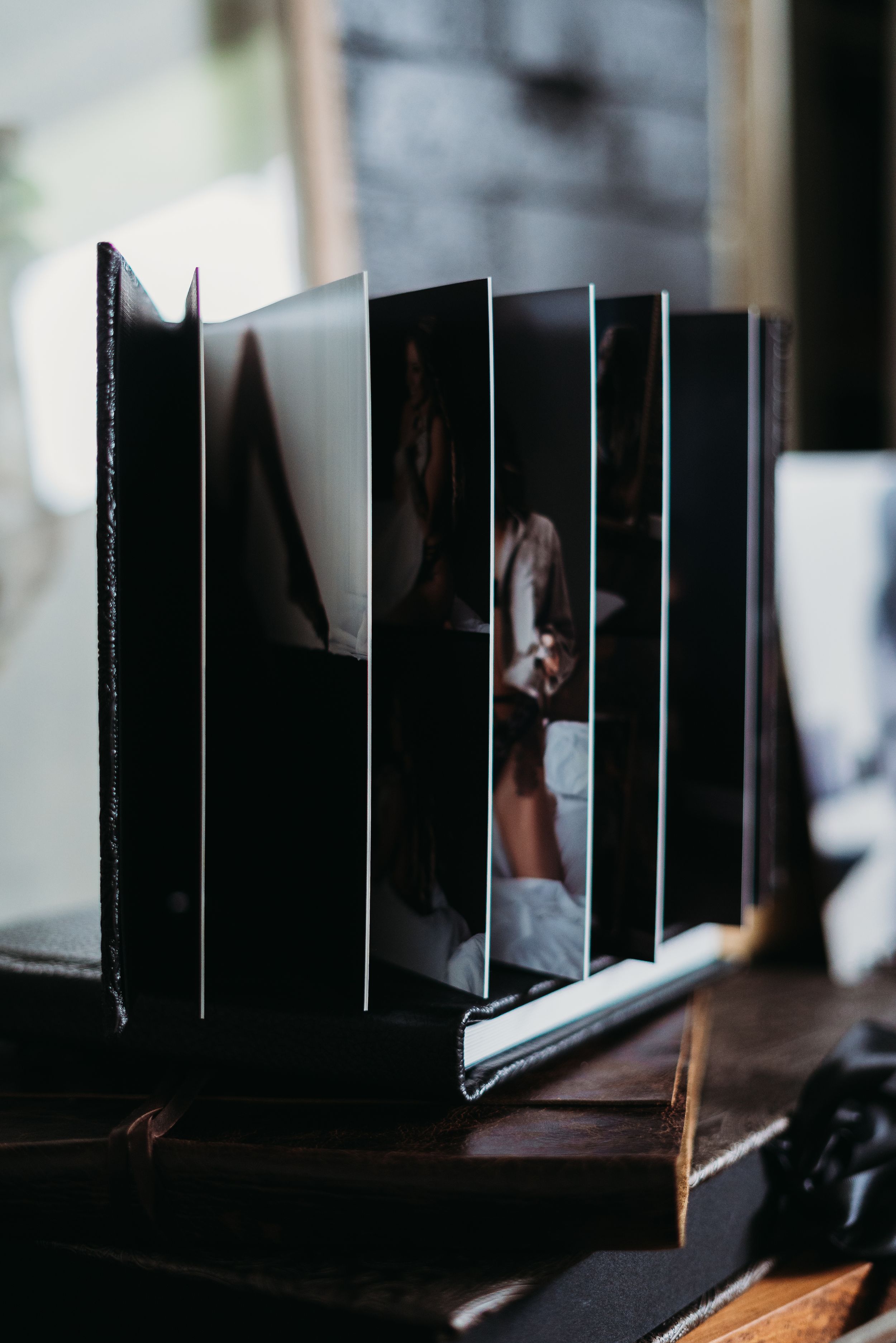 Side view of open photo album showing artistic portrait layouts.