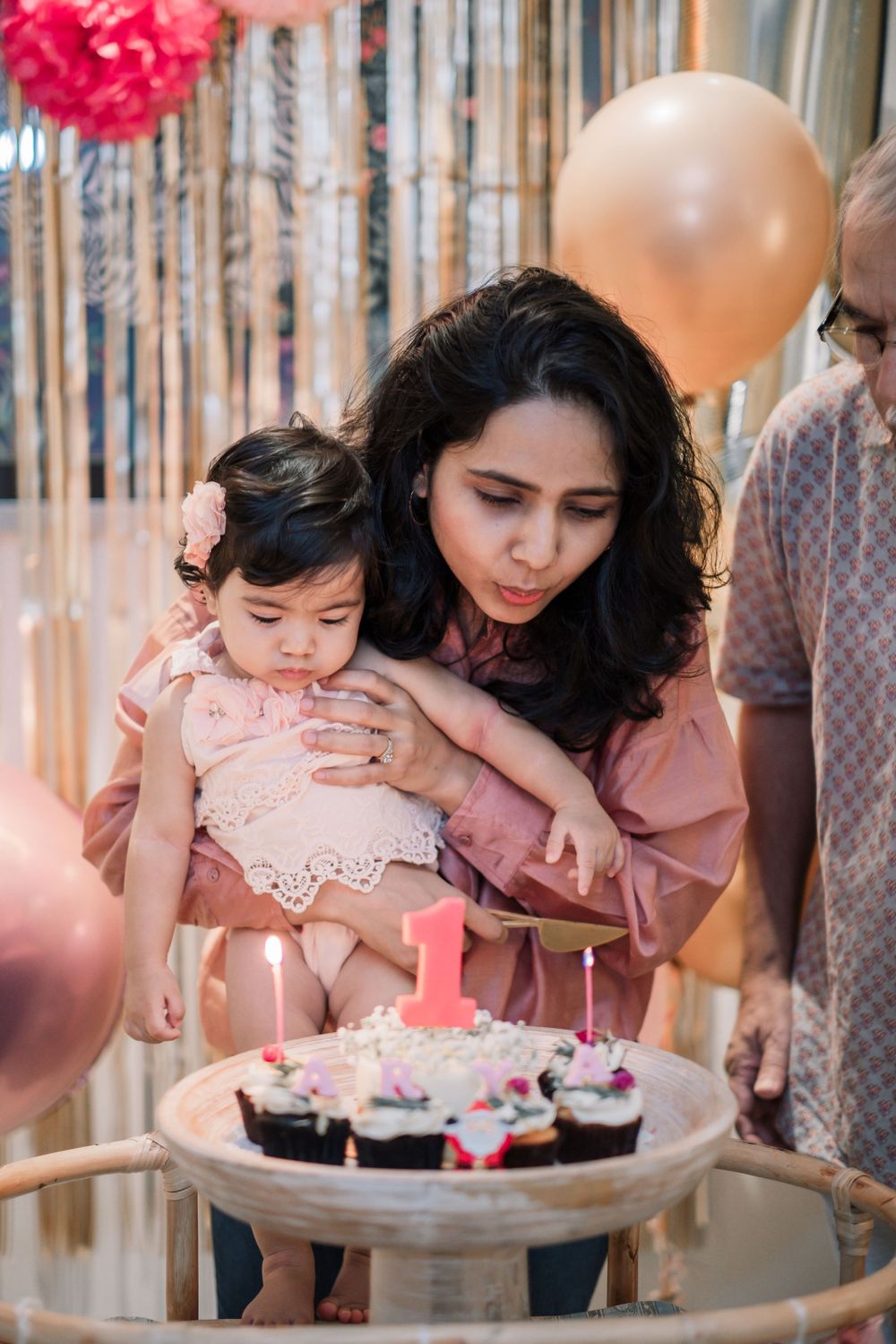 First birthday celebration with decorated cupcakes and pink party decor.