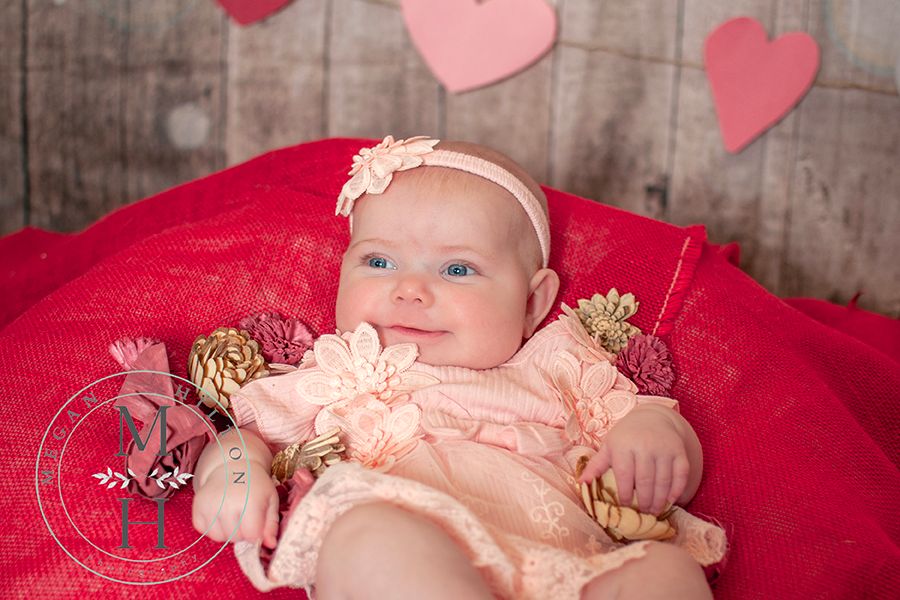Baby girl sitting with flowers