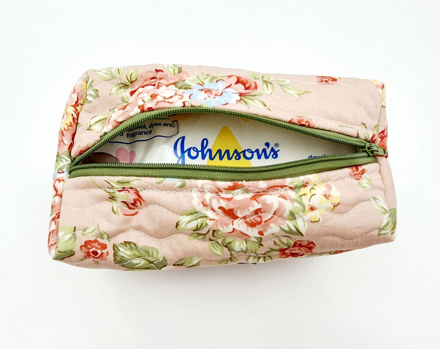 Johnson's wipes packet visible through floral print fabric pouch with zipper closure.