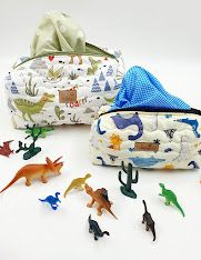 Colorful dinosaur and safari animal print baby accessories arranged in a row.