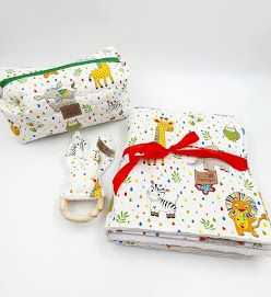 Baby accessories with colorful safari animal prints and red bow decorations.
