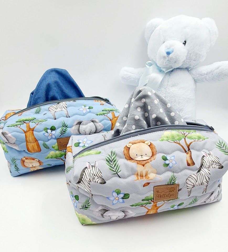 Baby accessories collection featuring safari animals and dinosaur prints in blue and gray tones.