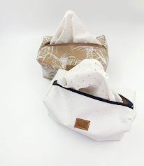 White fabric storage pouches with minimalist design displayed in various positions.