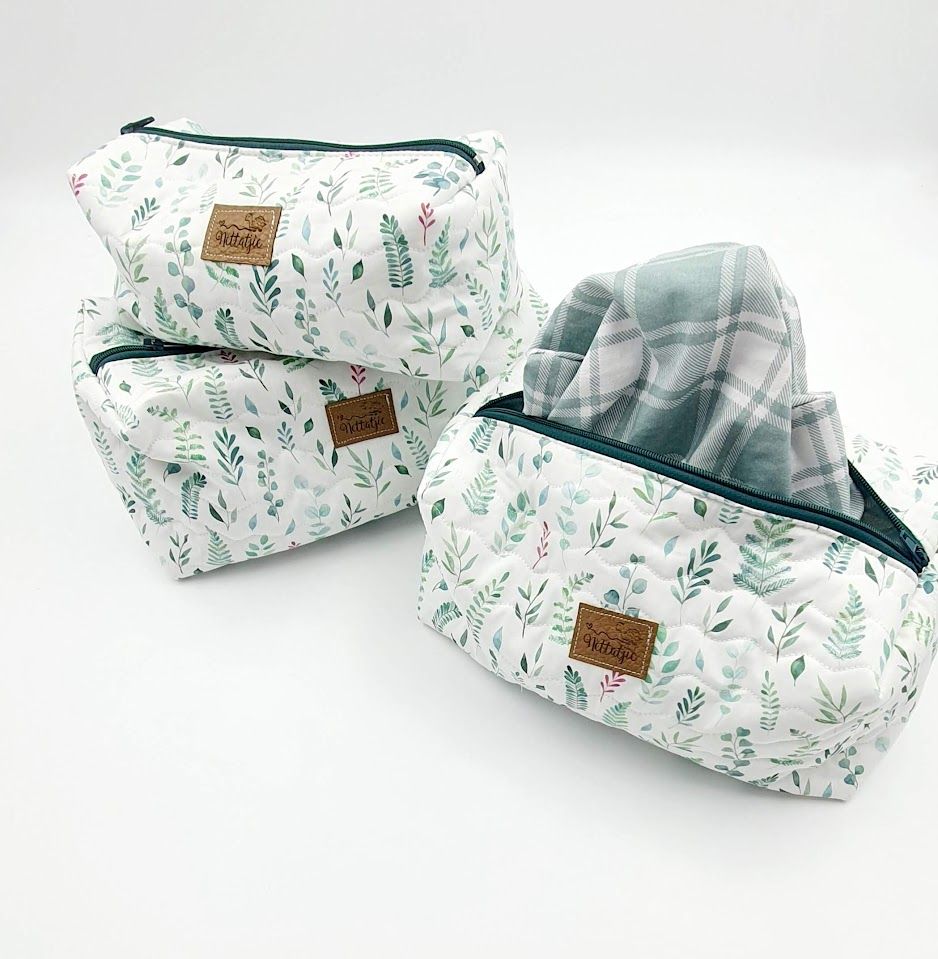 Floral pattern toiletry bags in white and mint green with leather accents displayed in various angles.