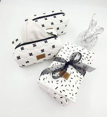 White cosmetic bags with black star pattern and leather details shown from different angles.