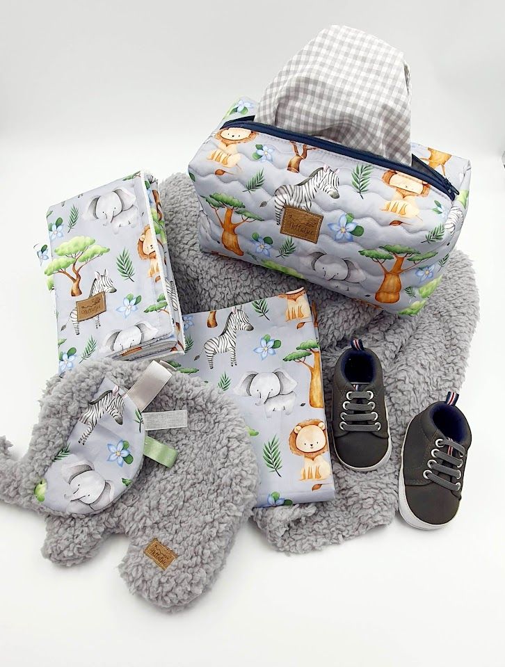 Grey plush baby blanket set with matching animal print accessories and black shoes.