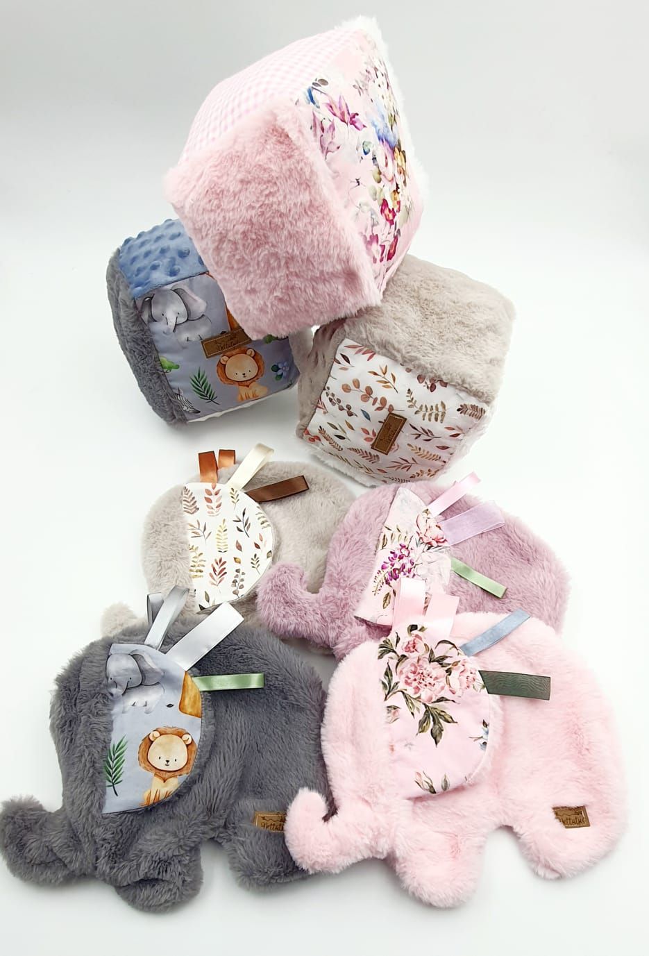 Collection of plush winter hats featuring animal designs in pink and gray colors.
